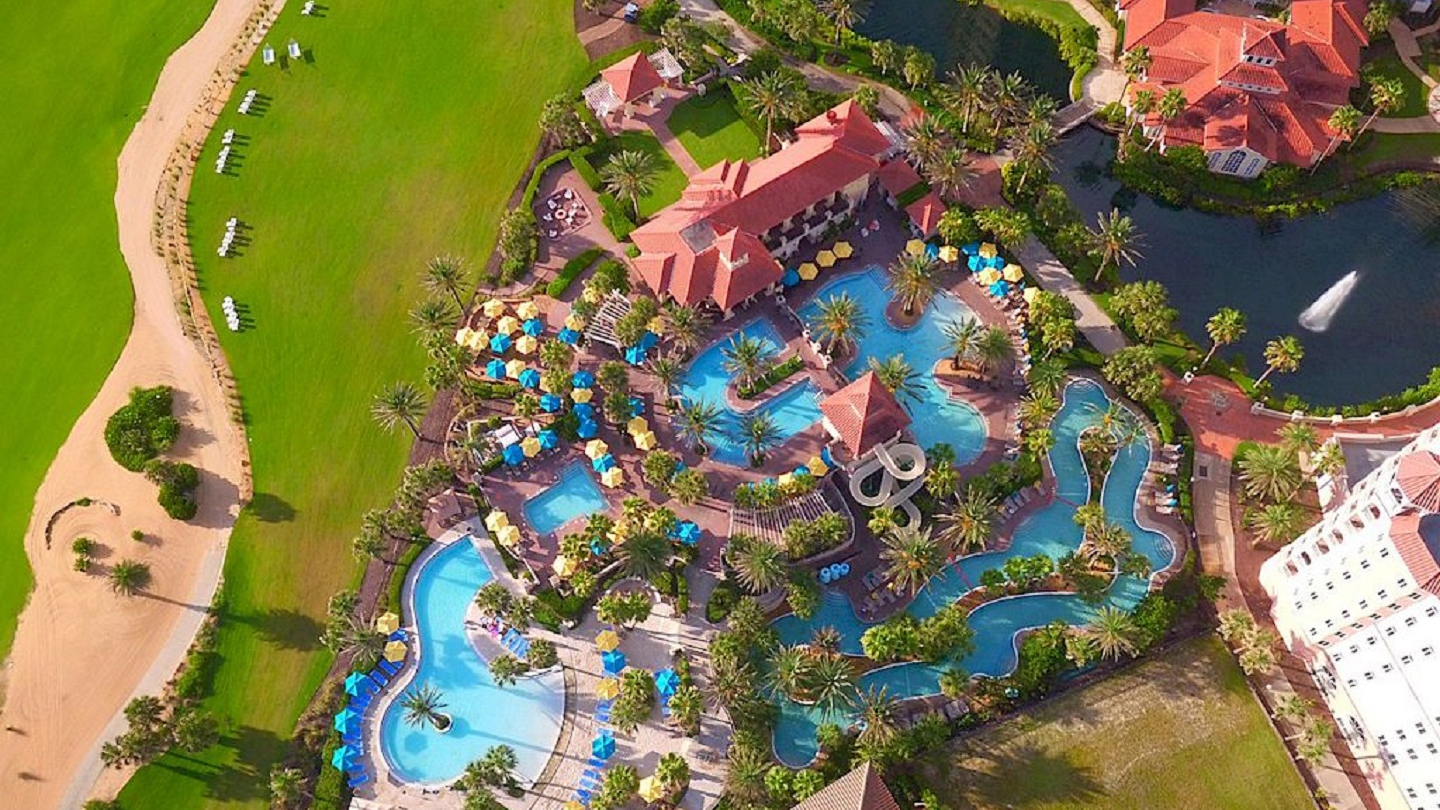 An aerial view of Hammock Beach Golf Resort showcasing the vibrant pool area, golf course, and lush surroundings.