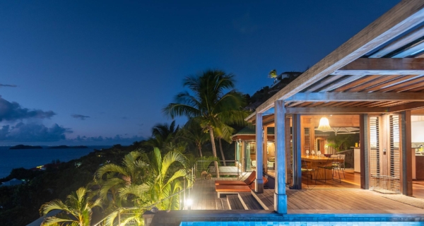 Luxury St. Barths Villa at Night – A stunning open-air villa in St. Barths, illuminated under the night sky, featuring an infinity pool, lush tropical surroundings, and breathtaking ocean views. The ultimate luxury escape for auction winners.