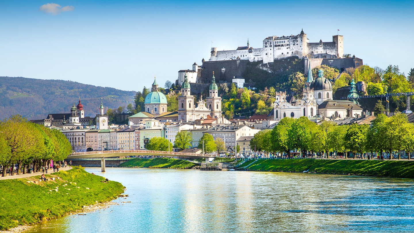 Panoramic view of Salzburg, Austria, featuring the iconic Hohensalzburg Fortress, scenic river, and historic old town.