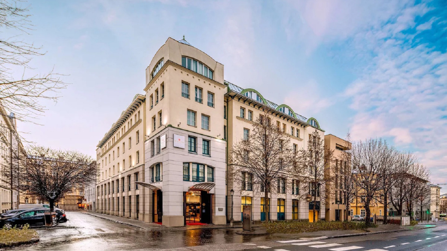 Elegant exterior of a luxury hotel in Salzburg, Austria, with modern architecture and a scenic urban backdrop.