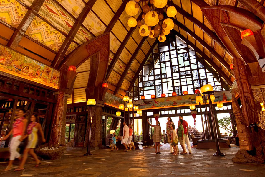 The grand lobby of Aulani features Hawaiian-inspired decor, intricate wooden details, and warm lighting that welcomes guests to the heart of the resort.