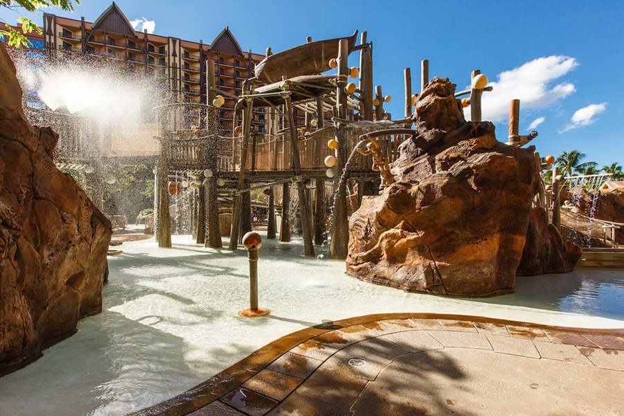 A close-up of Aulani’s dynamic pool area featuring water slides, splash zones, and rock formations, perfect for family fun and relaxation.