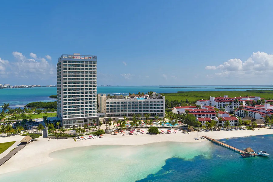 Aerial view of the modern Breathless Cancun Soul Resort & Spa with a pristine beachfront and turquoise waters, offering a tranquil yet vibrant escape.