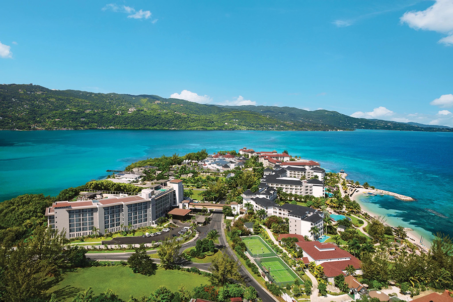 A breathtaking aerial perspective of the Breathless Montego Bay Resort & Spa, nestled between lush greenery and the sparkling Caribbean Sea.