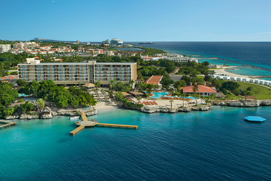 Picturesque island resort featuring turquoise waters, vibrant coral reefs, and a blend of relaxation and entertainment in Curaçao's tropical paradise.