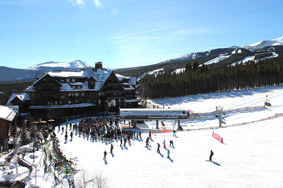 Grand Lodge on Peak 7 glowing warmly in the evening with snow-covered rooftops and ski slopes in Breckenridge, Colorado.