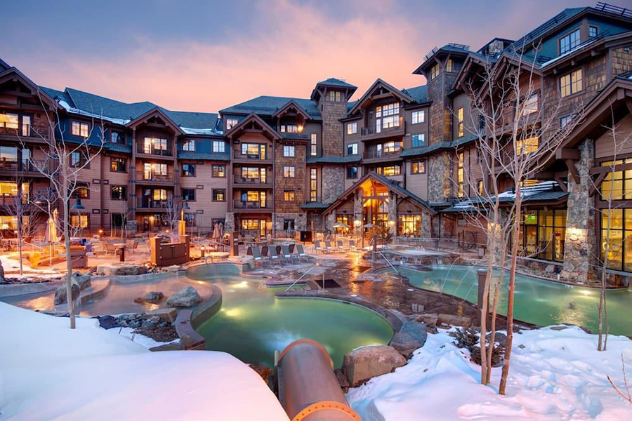 Grand Lodge on Peak 7 surrounded by skiers and snowy landscapes, featuring the Independence SuperChair ski lift.