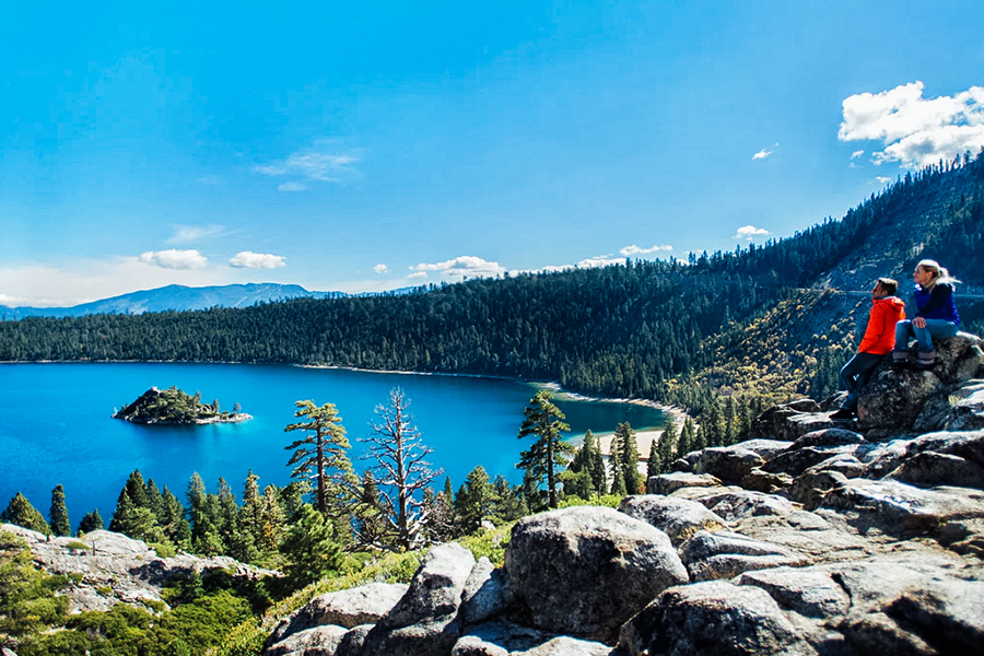 Hikers enjoying the scenic viewpoint overlooking Emerald Bay and Fannette Island in Lake Tahoe, California.