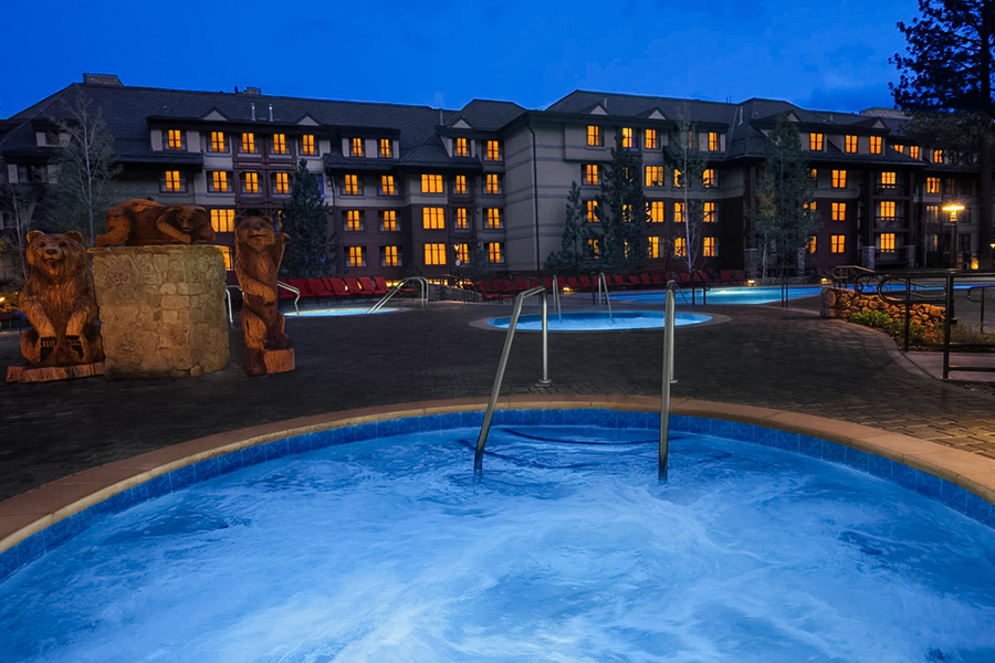 Outdoor whirlpool spa at Marriott’s Timber Lodge, illuminated at night with cozy lighting and mountain surroundings.