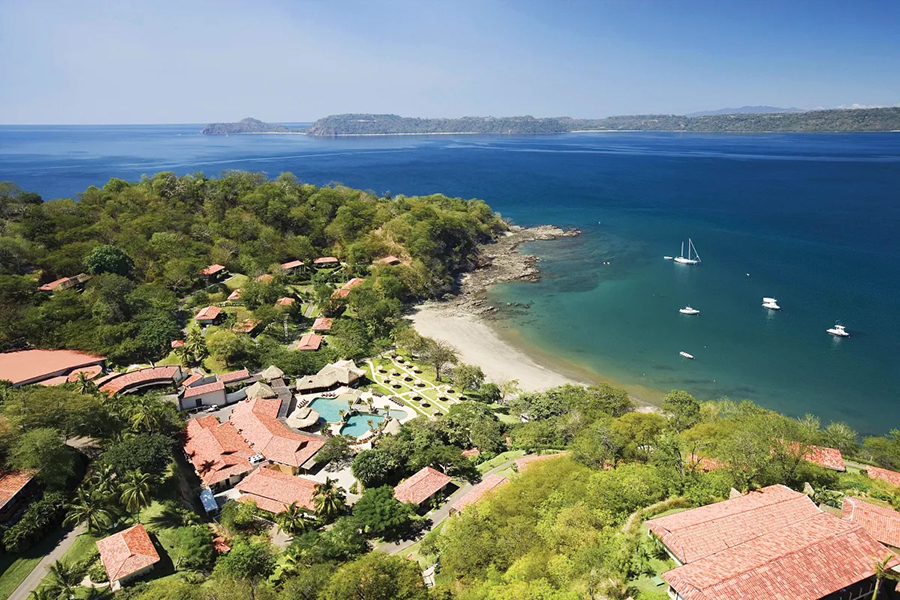 Scenic aerial view of Secrets Papagayo Costa Rica, located on a secluded bay with lush greenery and pristine oceanfront views.