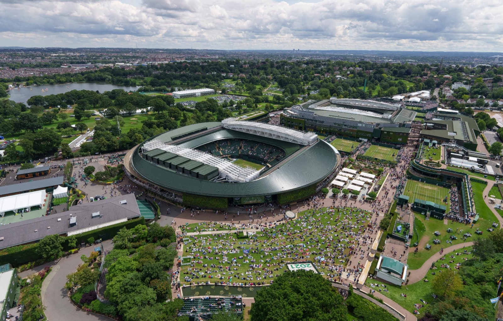 Aerial view of the Wimbledon Centre Court and surrounding tennis grounds, showcasing the excitement of The Championships in London.